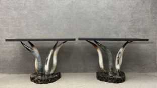A pair of console tables on faux horn bases with matched faux granite tops on shaped simulated
