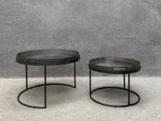 A pair of contemporary nesting side tables each having a circular distressed glass tray top with