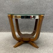 An Art Deco occasional table having a circular mirrored top with a bevelled plate on four curved