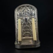 An early 20th century silver plated wall sconce having an arched back with scrolling repoussé
