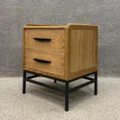 A contemporary oak bedside cabinet having a square top with a gallery back over two frieze drawers