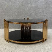 A contemporary Italian Mauris coffee table having a circular black tempered glass top and
