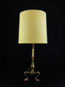 An Edwardian brass Pullman table lamp having a faceted baluster form stem raised on scrolling tripod