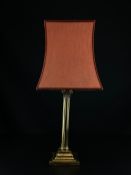 A 19th century neoclassical brass table lamp in the form of a Corinthian column having a pale red