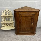 A 19th century wall mounted oak corner cabinet having a panelled door with canted sides on a moulded