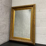 A large 19th century style gilt and gesso mirror having a rectangular bevelled plate in a moulded