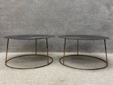 A pair of contemporary side or occasional tables each having a circular sheet metal top raised on