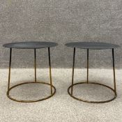 A pair of contemporary side tables each having a circular sheet metal top raised on a circular