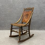 An early 20th century beech framed rocking chair having a shaped and carved top rail with six