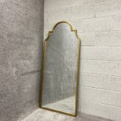 A contemporary floor or wall mirror having a shaped and stepped plate with an arched top in a
