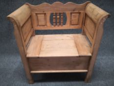 A late 19th century Scandinavian pine box settle having a shaped back with a spindled splat and