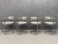 A set of four contemporary dining armchairs each having a tubular polished chrome tub style back and