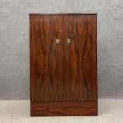 A mid-century faux rosewood metamorphic bookcase cabinet hinged at the sides to become an open