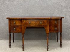 A Regency mahogany sideboard having a shaped breakfront top above a single frieze drawer with a