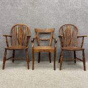 A pair of 20th century elm and ash wheelback Windsor armchairs each having an arched back with
