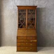 A 19th century oak bureau bookcase having a dentil moulded cornice over a pair of astragal glazed