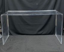 A contemporary desk custom made from a single bent sheet of thick bullet proof plexiglass. H.74 W.