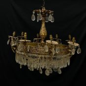 A 19th century chandelier having a pierced brass flowerhead finial above a repousse baluster form
