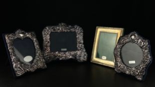 A collection of four hallmarked silver picture frames to include three vintage frames with