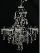A contemporary polished chrome chandelier having a narrow stem within a bulging openwork cage
