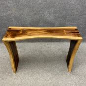 A contemporary hardwood console table of natural form having a curved top with split ends braced