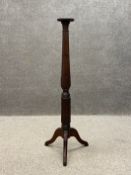 An Edwardian mahogany torchere plant stand having a circular moulded top raised on a turned carved