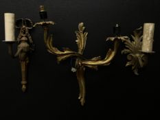 A collection of three 19th century and later gilt metal wall sconces to include one with a scrolling