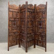 A 20th century Indian hardwood folding screen or room divider comprised of four panels each having a