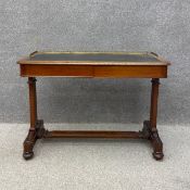 A William IV style 19th century walnut writing table having a black leather top with a pierced brass