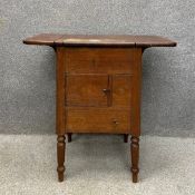 A 19th century oak side cabinet having a square top with two drop leaves over an arrangement of