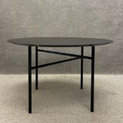 A contemporary ebonised ash dining table having a circular bevelled top over a pair of