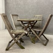 A contemporary distressed teak garden table with four matching chairs. H.74 W.92.5 D.92.5cm