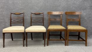 A pair of Regency mahogany dining chairs each having a carved top rail and a pierced and reeded