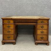 A 19th century walnut twin pedestal desk having a green and gilt tooled leather breakfront top