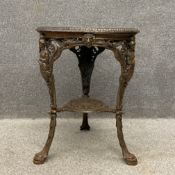 An early 20th century cast iron garden table having a circular top with pierced scrolling and