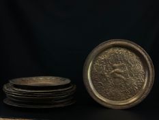 A collection of fourteen Eastern and other embossed and engraved brass, copper and tin trays with