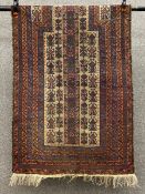 An Afghan Baluch prayer rug having a central geometric tree of life field over a biscuit ground
