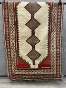 A handwoven Persian style kashkuli rug having a central strip of four flecked coffee diamond