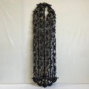 An early 20th century Oriental ebonised hardwood wall mount carved with an all-over openwork