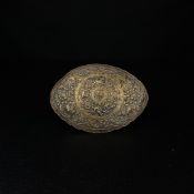 A 19th century Malaysian repousse gilt metal belt buckle of convex lozenge form having concentric