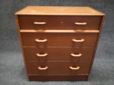 A mid century G-Plan E-Gomme teak writing bureau having a hinged fall front frieze drawer opening on