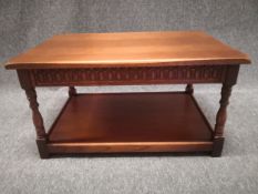 A 20th century oak coffee table having a rectangular top over a fluted frieze raised on carved and