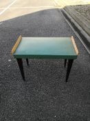 A mid century Art Deco style stool having a green upholstered seat with raised tulip wood sides