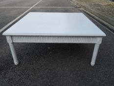 A 20th century painted coffee table having a square moulded top with a fluted frieze raised on round
