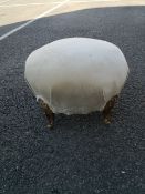 A small C.1900 footstool of ovoid bombe form upholstered in a cream velour raised on four short gilt
