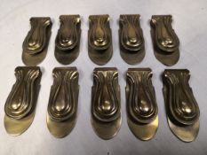 A collection of ten moulded brass curtain holders with impressed Trade Mark Clipper marks to the