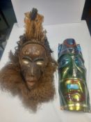 An African hand painted tribal ceremonial mask or headdress inset with a bed of bent iron nails