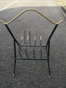 A mid century wrought metal magazine rack having a gilt wishbone shaped handle over the wirework