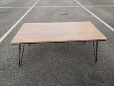 A 20th century coffee table having a rectangular faux teak top raised on tapered wrought steel rod