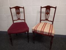 A pair of Edwardian rosewood and marquetry inlaid dining chairs on turned supports.